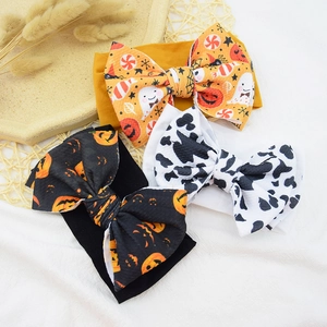 Detailed view of elastic nylon baby headbands with Halloween prints and cow patterns