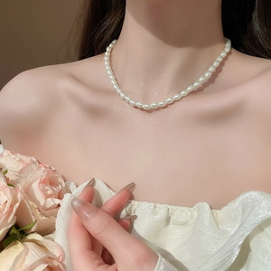 Close-up of elegant white rice pearl necklace worn by model featuring soft natural luster