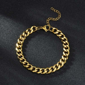 Polished gold Cuban link bracelet for couples with adjustable clasp on a dark surface