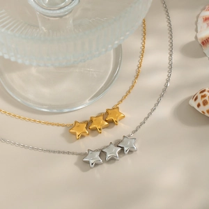 Elegant gold and silver star necklaces with three charms on a minimalist background