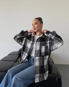 Detailed view of women's black and white plaid shirt with classic collar and front buttons