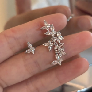 Macro shot of silver zircon butterfly ear crawlers with sparkling floral stone inlay