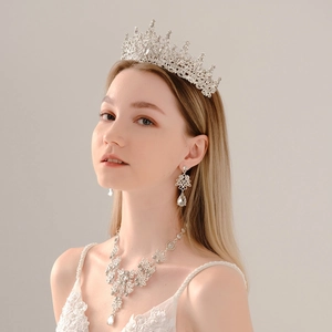 Close-up of silver bridal jewelry set with tiara, necklace and earrings on a model