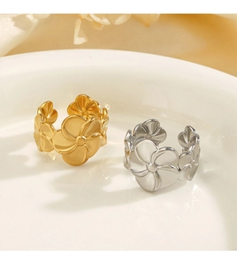 Detailed close-up of gold and silver floral rings displayed on a white ceramic dish