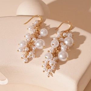 Close-up of vintage Baroque imitation pearl cluster tassel earrings with gold hooks