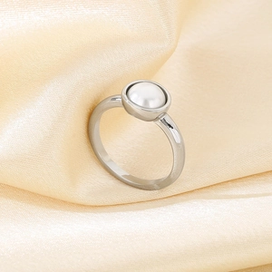 Detailaufnahme eines minimalistischen Silberrings aus Edelstahl mit Perle auf Satin