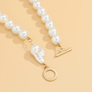 Detail view of baroque pearl pendant necklace with a golden OT toggle clasp and beads