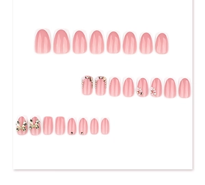 Detailed view of pink French press-on nails with golden bows and rhinestones.
