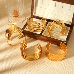 Collection of five 18K gold-plated stainless steel open bangles with unique textured designs