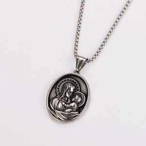 Macro detail of silver oval pendant featuring Madonna and Child relief with box chain