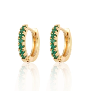 Macro shot of gold hoop earrings set with green round-cut cubic zirconia and mirror reflection