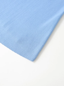 Close-up detail of light blue knitted denim fabric texture with professional stitching