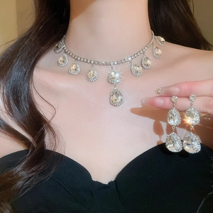 Detailed view of silver water drop necklace and earrings set with sparkling rhinestones