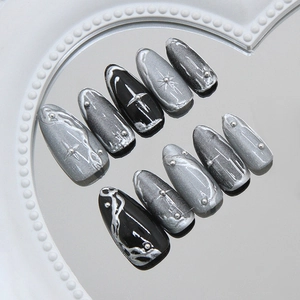 Cat eye press-on nails with silver star motifs and metallic texture on a mirror tray