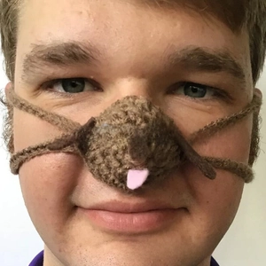 Macro detail of handmade knitted brown animal nose warmer with elastic ear loops