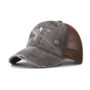 Dettaglio laterale del cappello trucker in cotone lavato con ricamo libellula e rete