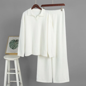 Detail of white knit polo sweater and wide leg trousers set with soft plush texture