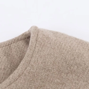 Gros plan détaillé des coutures et de la texture douce du col de la veste en simili beige