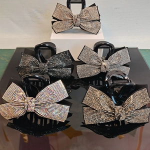 Detail showing five rhinestone bow hair claws in black, silver and multi-colors