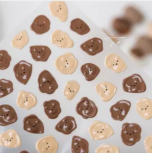 Macro detail of 3D bear nail stickers with high-gloss finish and cream jelly textures