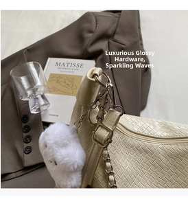 Detail of cream woven shoulder bag with metal chain and cute plush bear charm accessory
