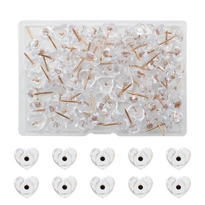 Macro detail of heart-shaped push pins with rose gold pins in a transparent storage box