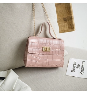 Détail du sac à main rose pastel motif crocodile avec chaîne et fermoir dorés