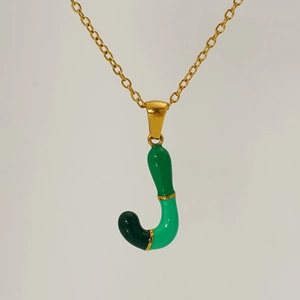 Macro shot of letter J pendant with green enamel segments on golden link chain