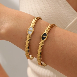 Detailed view of titanium steel serrated oval bracelets with black and white enamel inlays