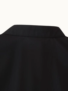 Detail of the back collar and stitching on a black vacation-style dress with fine texture