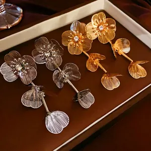 Boucles d'oreilles fleurs à pompons avec strass incrustés en finitions or et argent