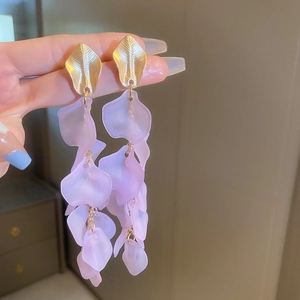 Detail of elegant gold leaf studs with translucent purple acrylic flower petal tassels