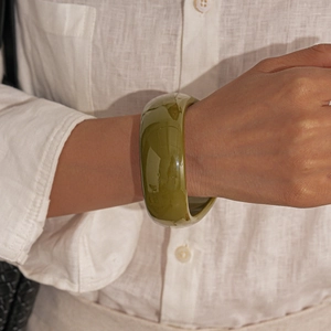 Macro view of wide olive green acrylic resin bangle with smooth polished finish