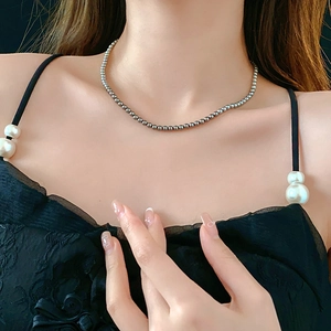 Close-up of elegant silver-gray pearl necklace worn by a model on the collarbone