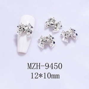 Detailed view of silver bow nail art charms with heart rhinestones, size 12x10mm