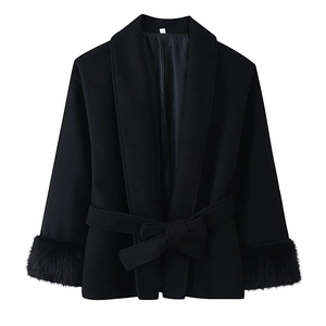 Detail of luxurious faux fur cuffs and matching waist tie on a black wool coat