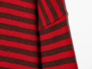 Gros plan d'un pull en maille à rayures rouges et brunes montrant les détails de couture
