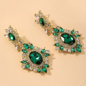 Detail of vintage emerald flower earrings with gold plating and sparkling rhinestones