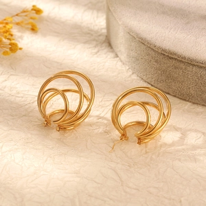 Detailed macro shot of golden irregular multi-layered overlapping stainless steel hoop earrings