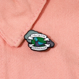 Funny pigeon enamel pin with 'I WILL SHIT ON EVERYTHING YOU LOVE' text on pink denim