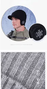 Close-up of black winter knit baseball cap with snowflake earflaps and warm plush lining