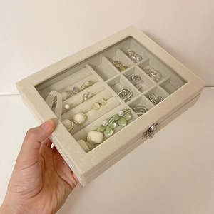 Macro detail of velvet jewelry box featuring transparent glass lid and ring slots