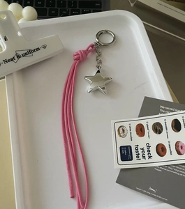 Close-up of pink woven tassel keychain with silver metal star charm and key ring