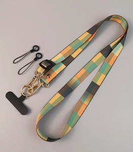 Detail view of woven phone strap with green-yellow patterns and gold hardware