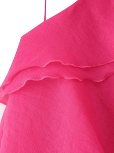 Close-up of layered rose red chiffon ruffles and fine stitching on a mini skirt