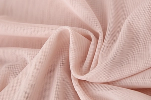 Macro shot of the delicate light pink pleated mesh fabric and fine net texture of the top