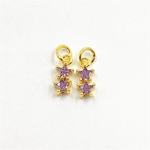 Detailed view of two purple star-shaped charms with gold-plated metal and zircon accents