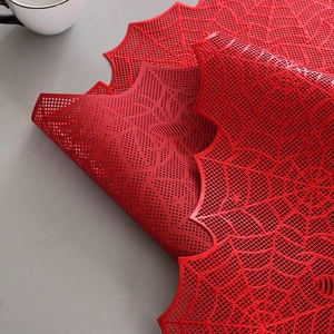 Macro detail of red spiderweb table runner with intricate hollowed patterns
