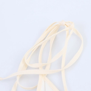 Dettaglio ravvicinato delle spalline in cotone e lino beige di un elegante abito lungo