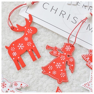 Close-up of red wooden Christmas ornaments with snowflake patterns on white plush background